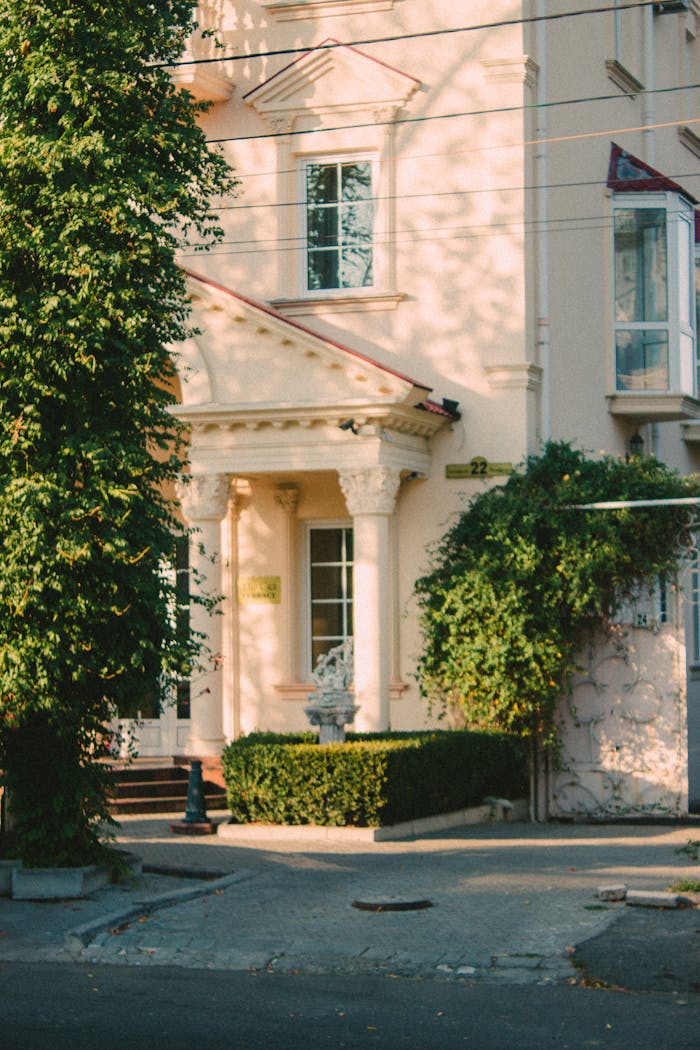 Classical facade of an elegant building in sunlight with lush greenery in Nikoleav, Ukraine.